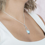 The picture shows a model wearing a 925 sterling silver larimar lunar eclipse pendant.