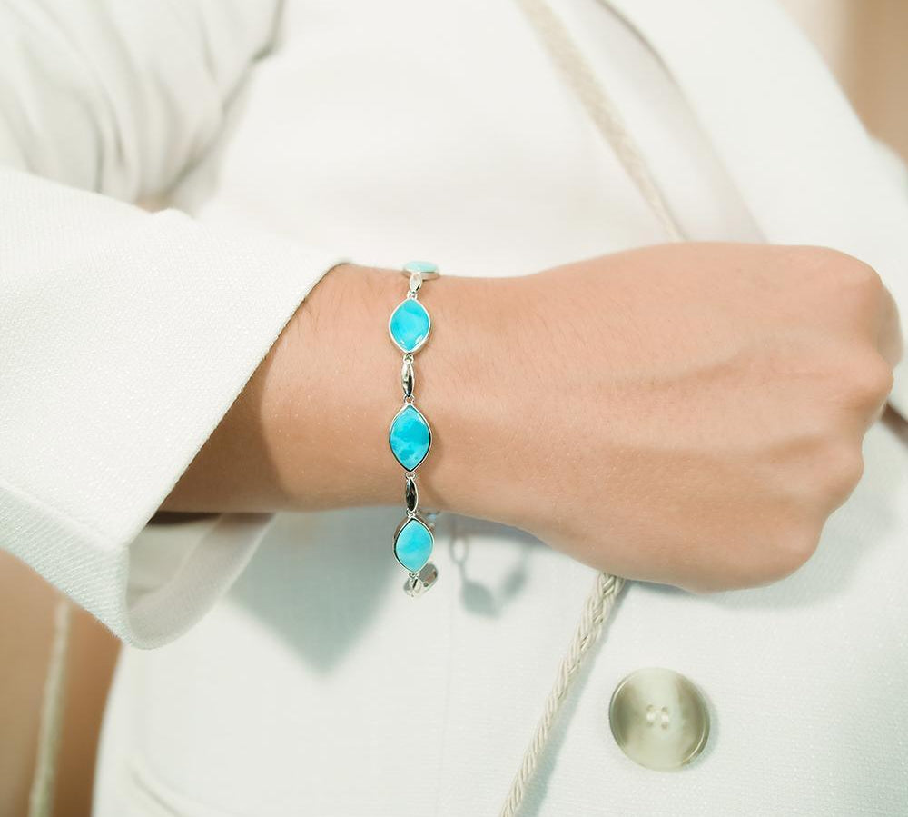 The picture shows a model wearing a 925 sterling silver larimar mandorla bracelet.