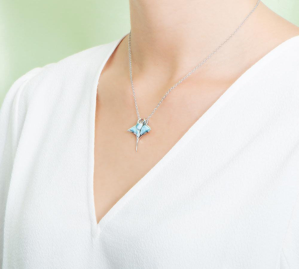 The picture shows a model wearing a 925 sterling silver larimar manta ray pendant.
