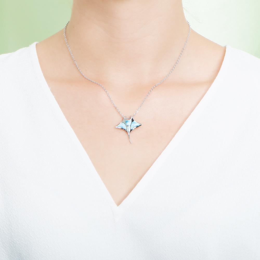 The picture shows a model wearing a 925 sterling silver larimar manta ray pendant.
