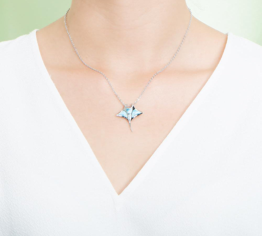 The picture shows a model wearing a 925 sterling silver larimar manta ray pendant.