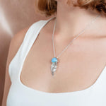 The picture shows a model wearing a 925 sterling silver larimar medusa jellyfish pendant.