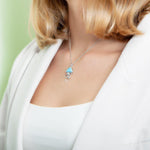 The picture shows a model wearing a 925 sterling silver larimar moon jellyfish pendant.