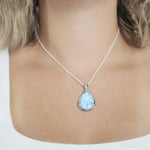 The picture shows a model wearing a 925 sterling silver larimar teardrop pendant.
