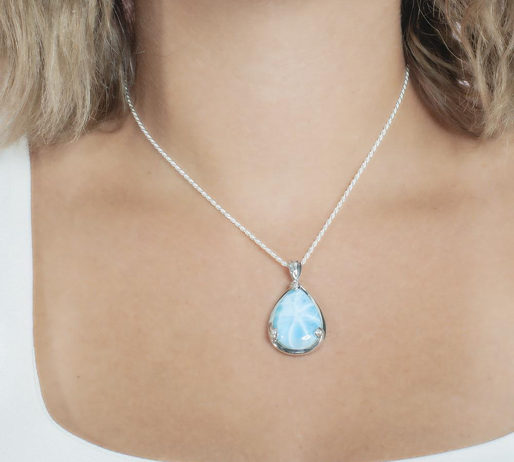 The picture shows a model wearing a 925 sterling silver larimar teardrop pendant.