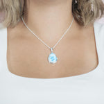 The picture shows a model wearing a 925 sterling silver larimar teardrop pendant.