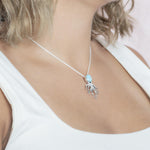 The picture shows a model wearing a 925 sterling silver larimar octopus pendant.