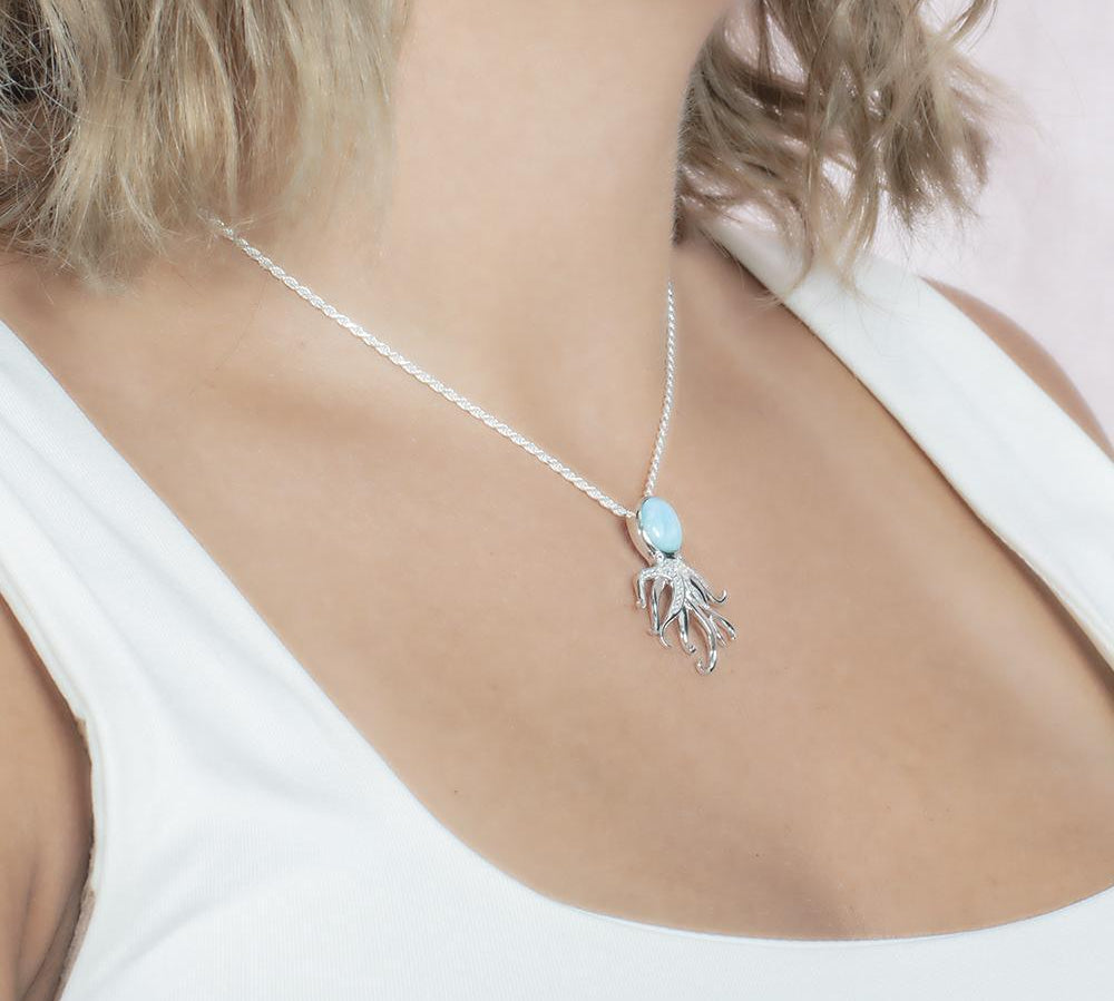 The picture shows a model wearing a 925 sterling silver larimar octopus pendant.