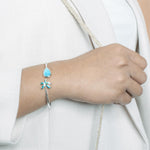 This photo shows a model wearing a 925 sterling silver larimar teardrop and opalite palm tree banle