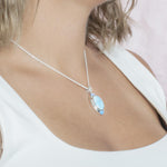 The picture shows a model wearing a 925 sterling silver larimar oval pendant.