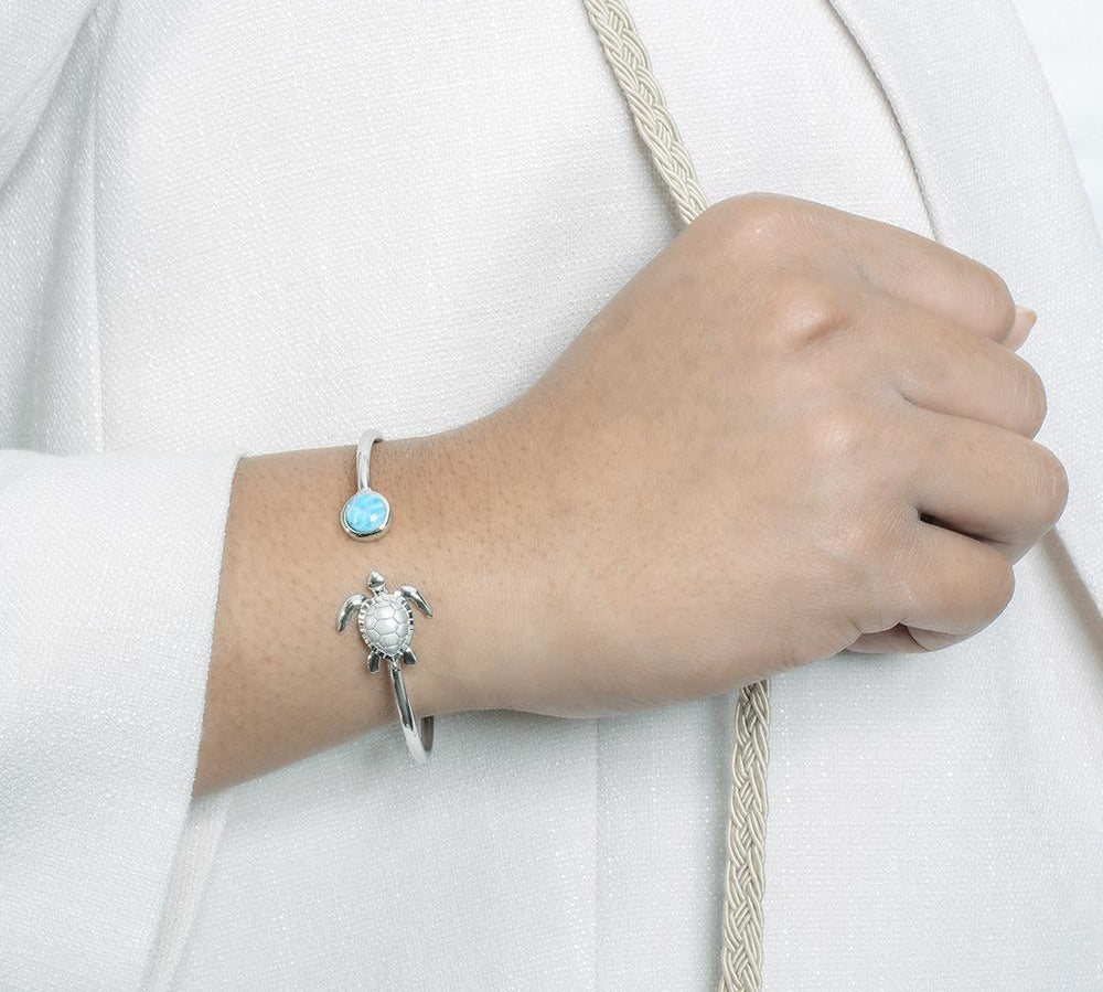 The picture shows a model wearing a 925 sterling silver larimar sea turtle bangle.