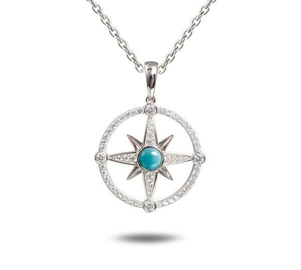 In this photo there is a sterling silver compass pendant with blue larimar and topaz gemstones.