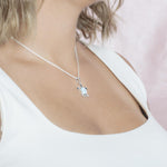 The picture shows a model wearing a 925 sterling silver larimar sea turtle pendant.