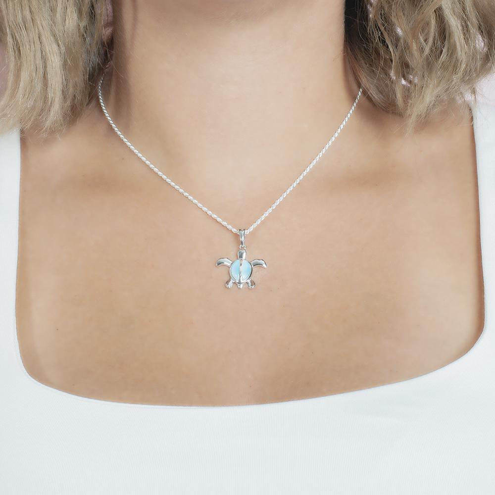 The picture shows a model wearing a 925 sterling silver larimar sea turtle pendant.