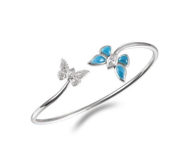 In this photo there is a sterling silver bangle with two butterflies and blue larimar, topaz, and aquamarine gemstones.