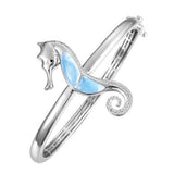 The picture shows a 925 sterling silver larimar seahorse bangle with topaz.