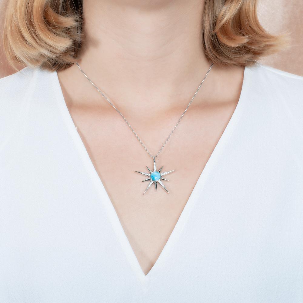 The picture shows a model wearing a 925 sterling silver larimar shooting star pendant.