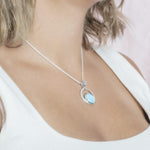 The picture shows a model wearing a 925 sterling silver larimar solar pendant.