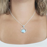 The picture shows a model wearing a 925 sterling silver larimar solar pendant.
