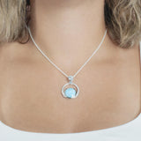 The picture shows a model wearing a 925 sterling silver larimar solar pendant.