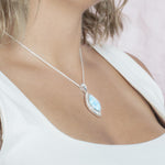 The picture shows a model wearing a 925 sterling silver larimar stars slign mandorla pendant.