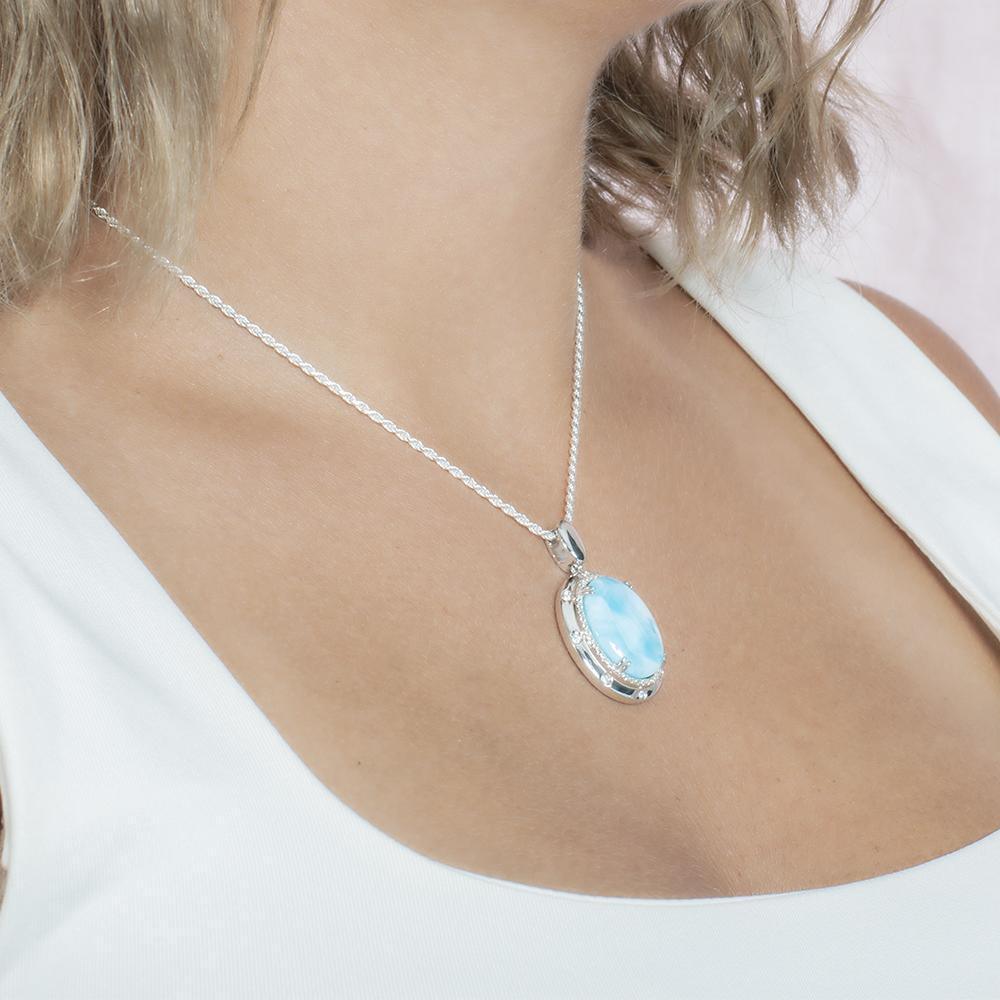The picture shows a model wearing a 925 sterling silver larimar stars align pendant.