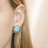 In this photo there is a model wearing a 925 sterling silver sun stud earring with a blue larimar gemstone