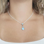 The picture shows a model wearing a 925 sterling silver larimar pendant featuring two circles and a teardrop in the center.