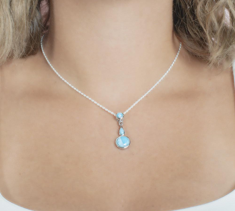 The picture shows a model wearing a 925 sterling silver larimar pendant featuring two circles and a teardrop in the center.