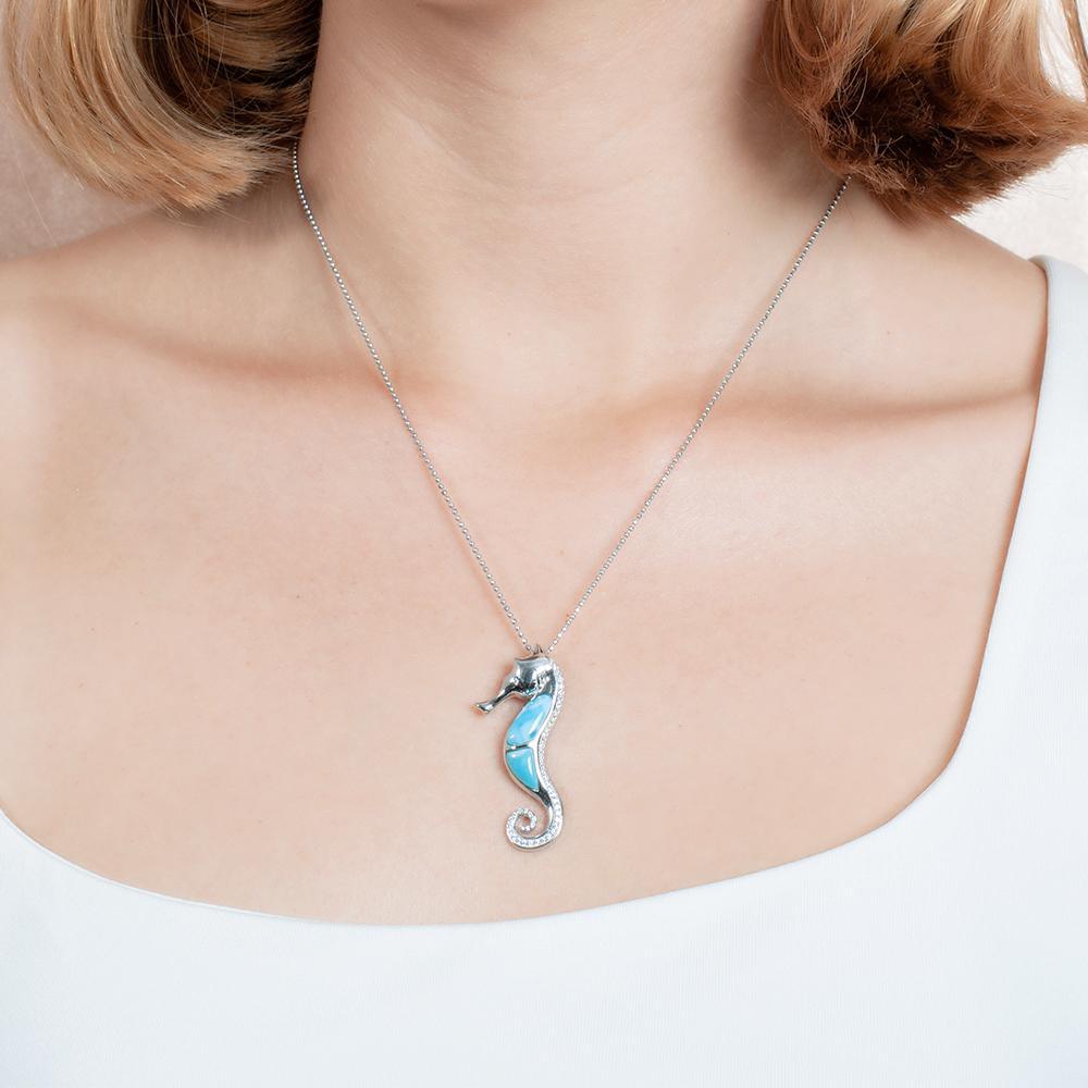The picture shows a model wearing a 925 sterling silver larimar seahorse pendant.