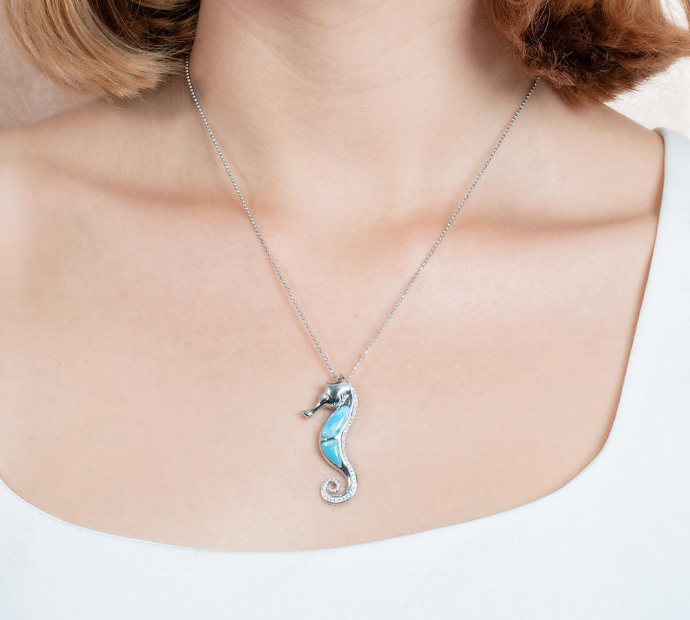 The picture shows a model wearing a 925 sterling silver larimar seahorse pendant.