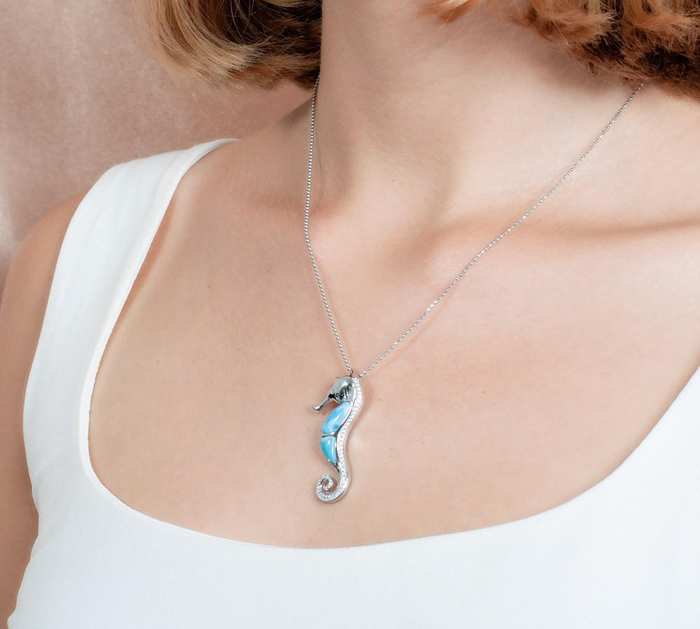 The picture shows a model wearing a 925 sterling silver larimar seahorse pendant.