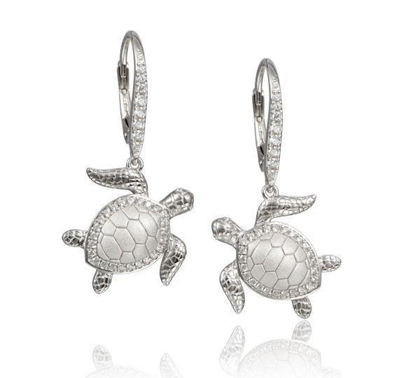 The picture shows a pair of 925 sterling silver sea turtle lever-back earrings with topaz.