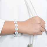 The picture shows a 925 sterling silver white gold-plated sand dollar bracelet with topaz