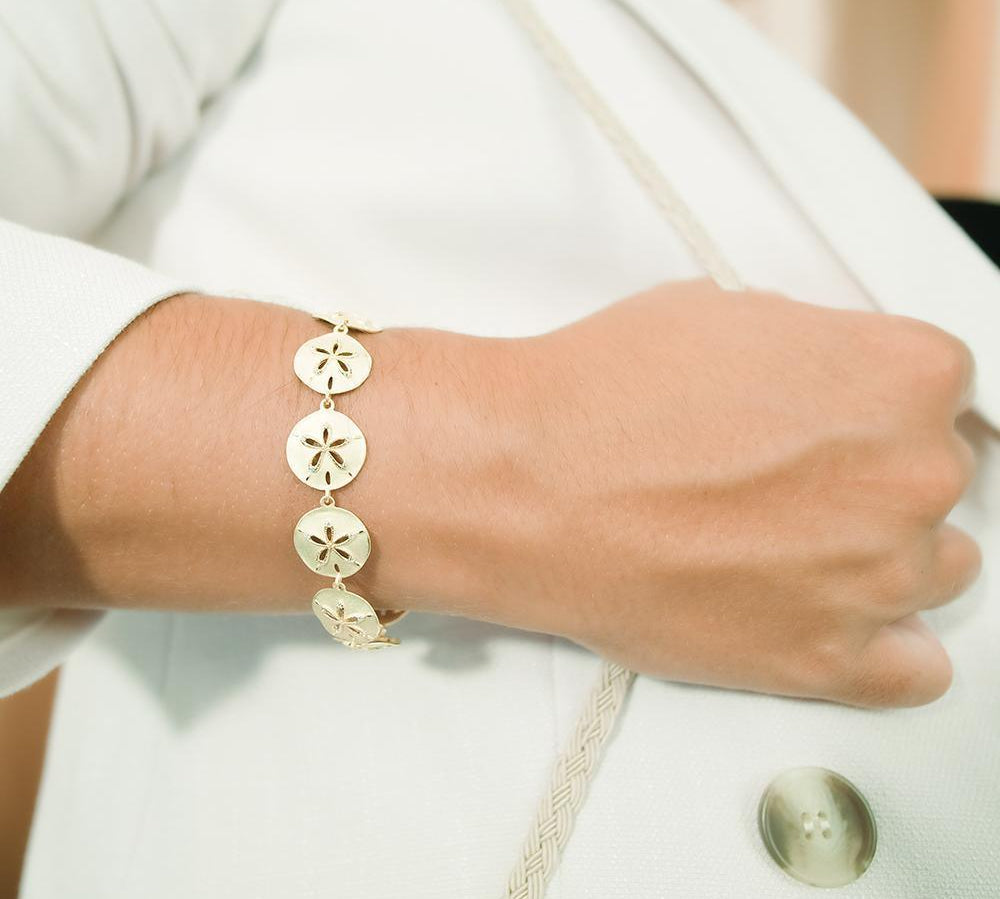 The picture shows a 925 sterling silver yellow gold-plated sand dollar bracelet with topaz