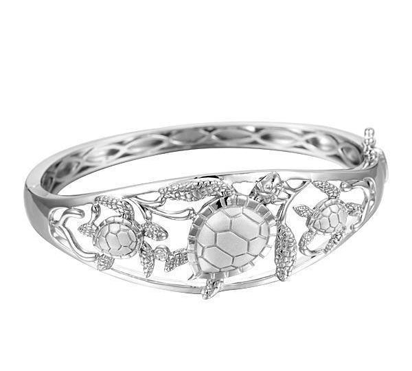 The picture shows a 925 sterling silver three sea turtle bangle with topaz.