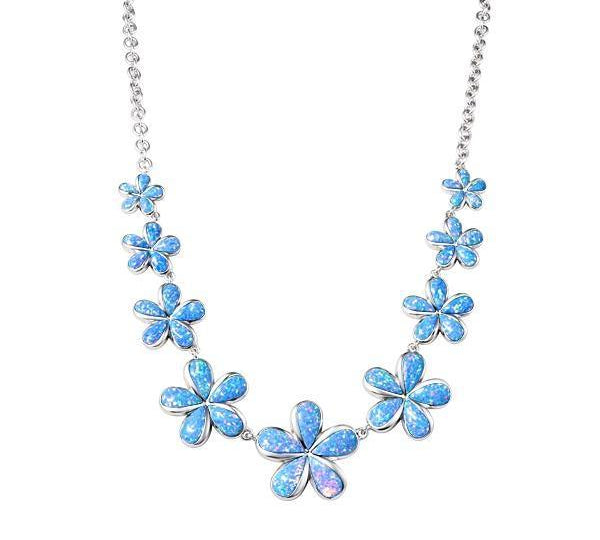 In this photo there is a sterling silver necklace with nine plumeria flowers and blue opalite gemstones.
