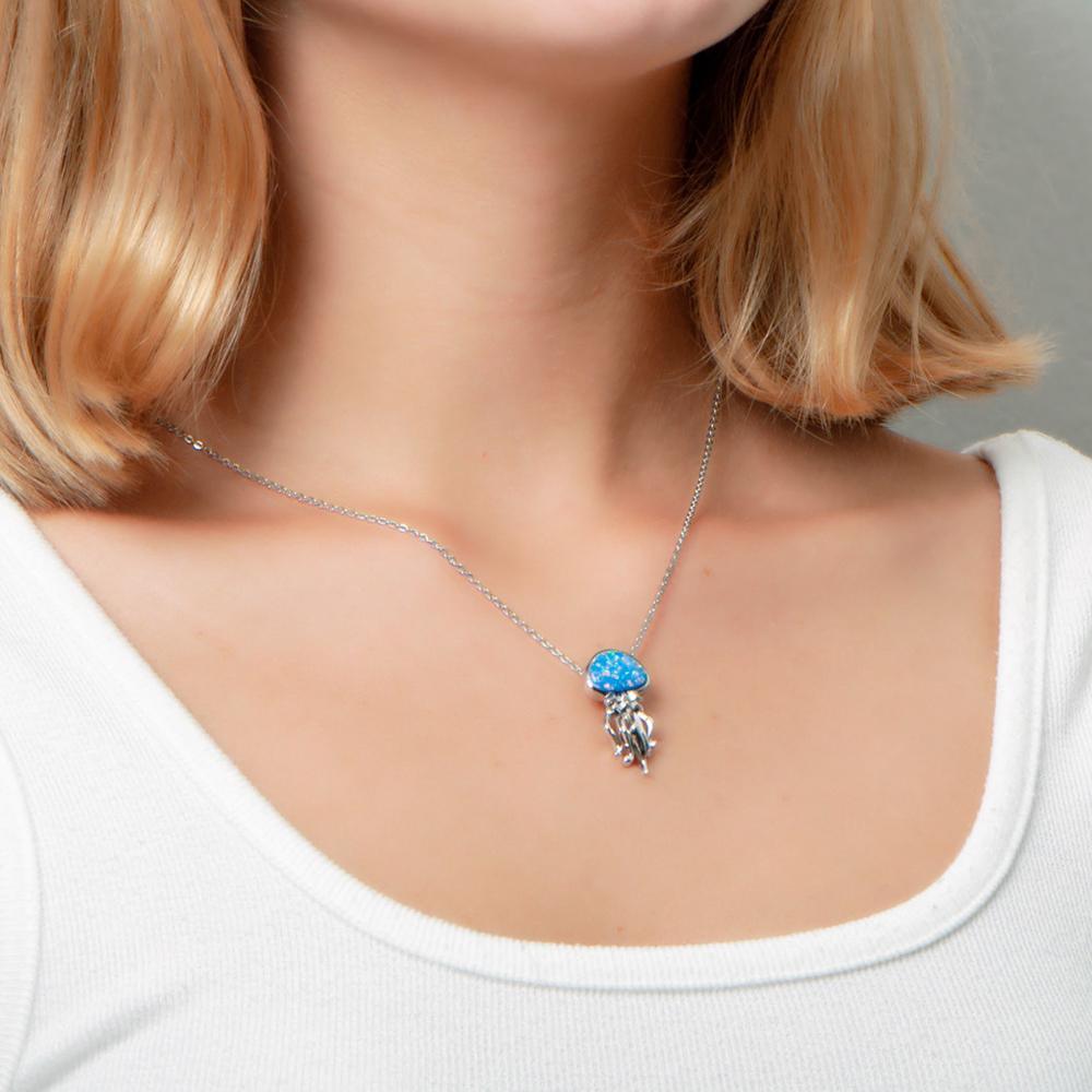 The picture shows a model wearing a 925 sterling silver opalite button jellyfish pendant.