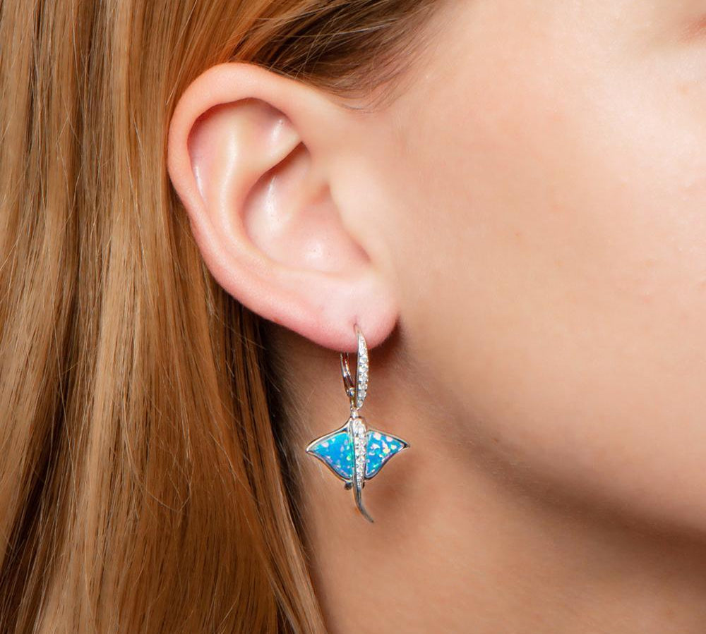 The picture shows a model wearing a 925 sterling silver opalite eagle ray earring with cubic zirconia.