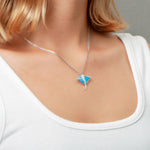 The picture shows a model wearing a 925 sterling silver opalite eagle ray pendant with cubic zirconia.