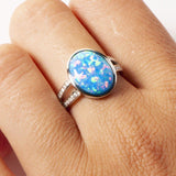 This image shows a model wearing a 925 sterling silver split band ring paired with an oval blue opalite gemstone and topaz