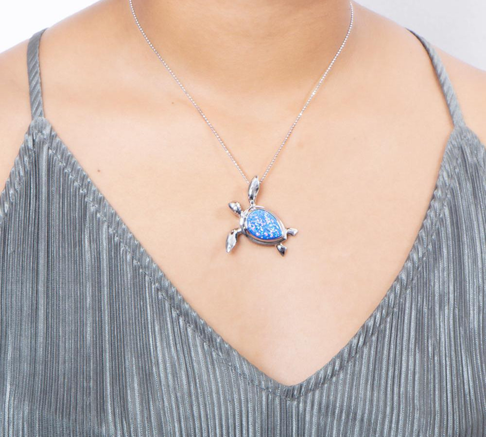 The picture shows a model wearing a 925 sterling silver opalite sea turtle pendant.