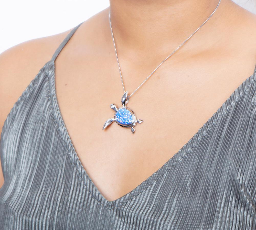 The picture shows a model wearing a 925 sterling silver opalite sea turtle pendant.