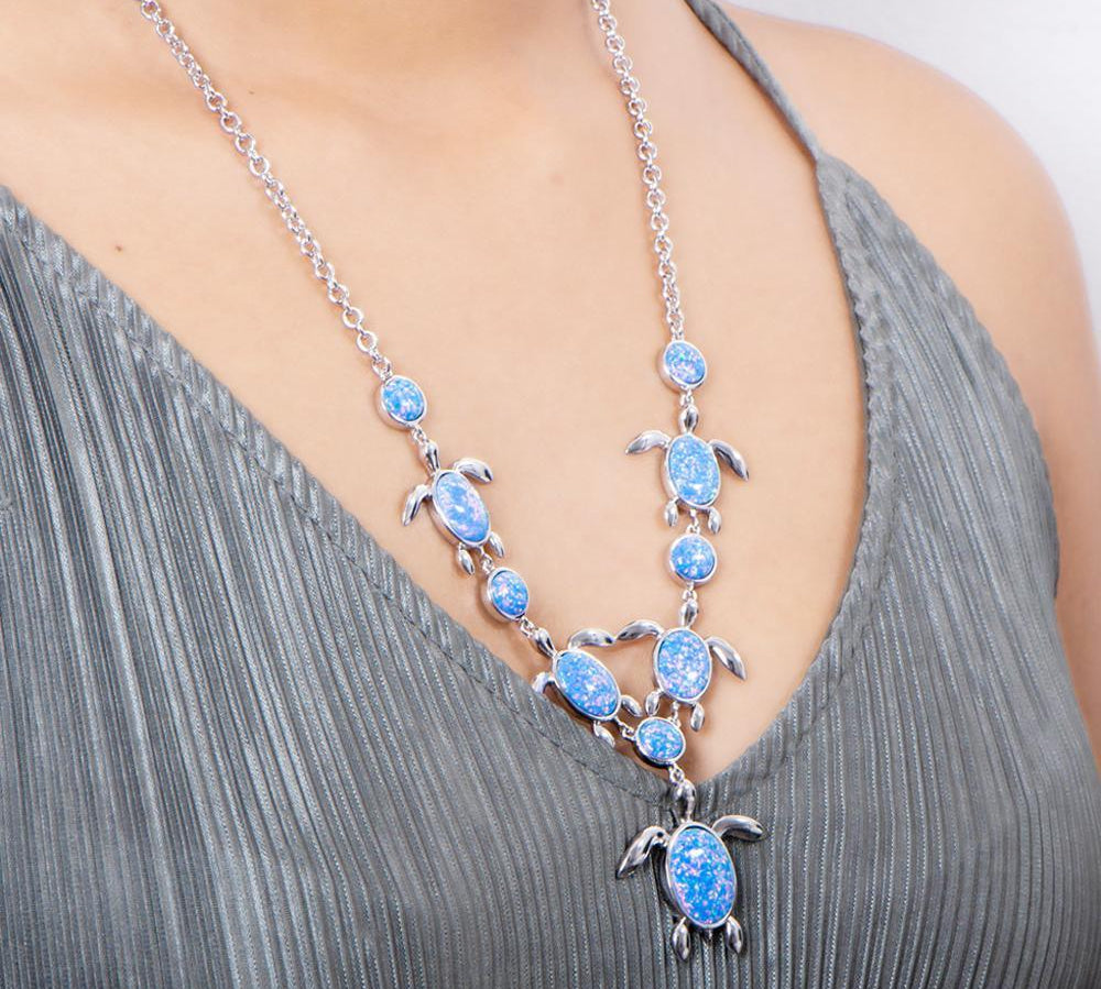 The picture shows a model wearing a 925 sterling silver opalite sea turtle charm necklace.