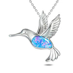 In this photo there is a sterling silver hummingbird pendant with topaz and blue opalite gemstones.