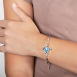 The picture shows a model wearing a 925 sterling silver opalite sea turtle bracelet.