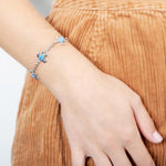 The picture shows a model wearing a 925 sterling silver opalite sea turtle charm bracelet