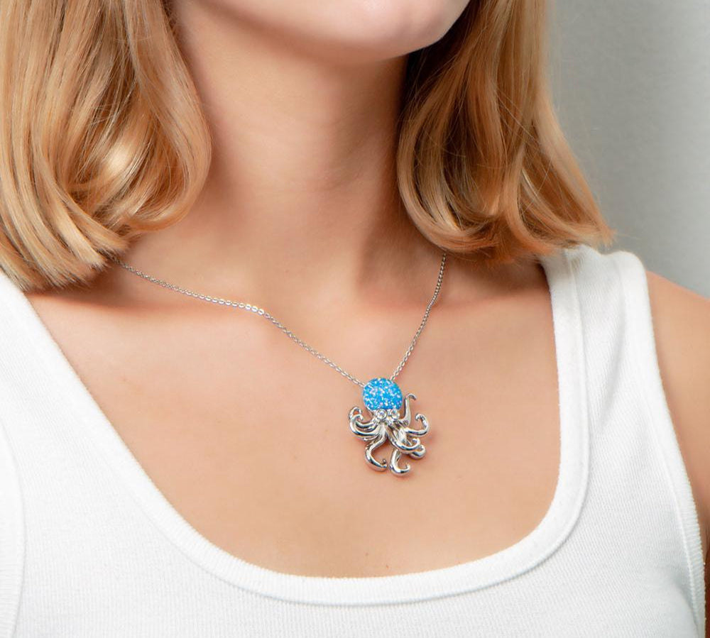 The picture shows a model wearing a 925 sterling silver opalite octopus pendant with topaz.