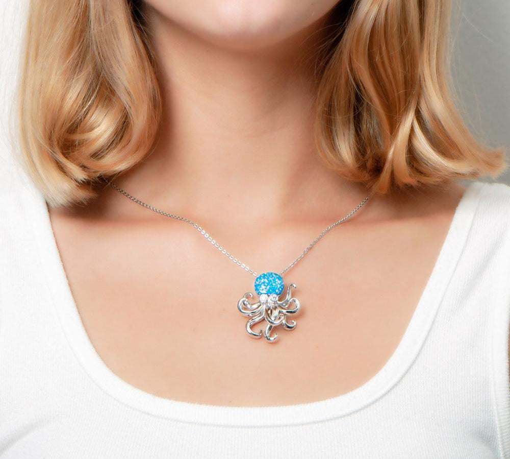 The picture shows a model wearing a 925 sterling silver opalite octopus pendant with topaz.
