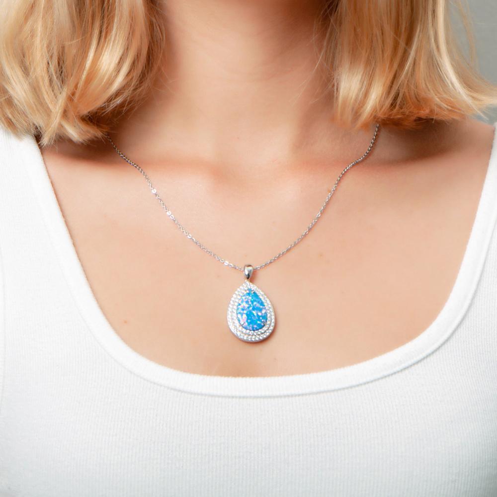 The picture shows a model wearing a 925 sterling silver opalite teardrop pendant with cubic zirconia.